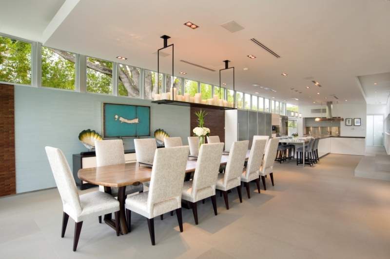 Large indoor eating area with wood table, fabric covered chairs 