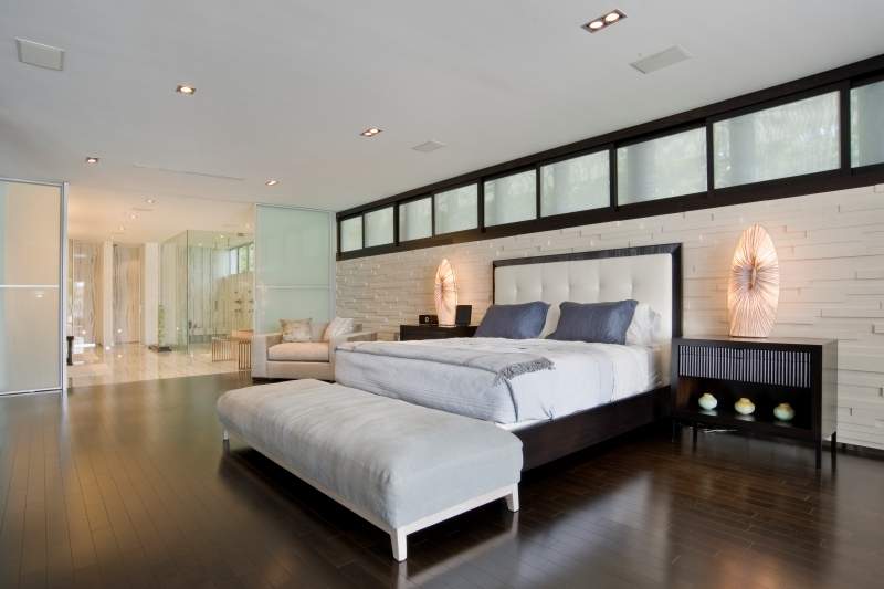 Large open bedroom, dark wood floors, king size bed